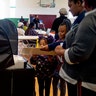 A pair of young girls helping their mother submit her ballot at Haskell Community Center in Flint, Michigan.