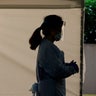 A nurse at a drive-up coronavirus testing station set up by the University of Washington Medical Center wears a face shield and other protective gear as she waits by a tent Friday, March 13, 2020, in Seattle. UW Medicine is conducting drive-thru testing in a hospital parking garage and has screened hundreds of staff members, faculty and trainees for COVID-19. U.S. hospitals are setting up triage tents, calling doctors out of retirement, guarding their supplies of face masks and making plans to cancel elective surgery as they brace for an expected onslaught of coronavirus patients.