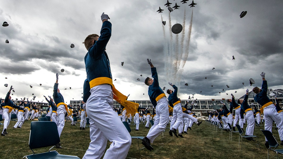 COLORADO SPRINGS, CO - APRIL 18: Spaced eight feet apart, United States Air Force Academy cadets celebrate their graduation as a team of F-16 Air Force Thunderbirds fly over the academy on April 18, 2020 in Colorado Springs, Colorado. (Photo by Michael Ciaglo/Getty Images)