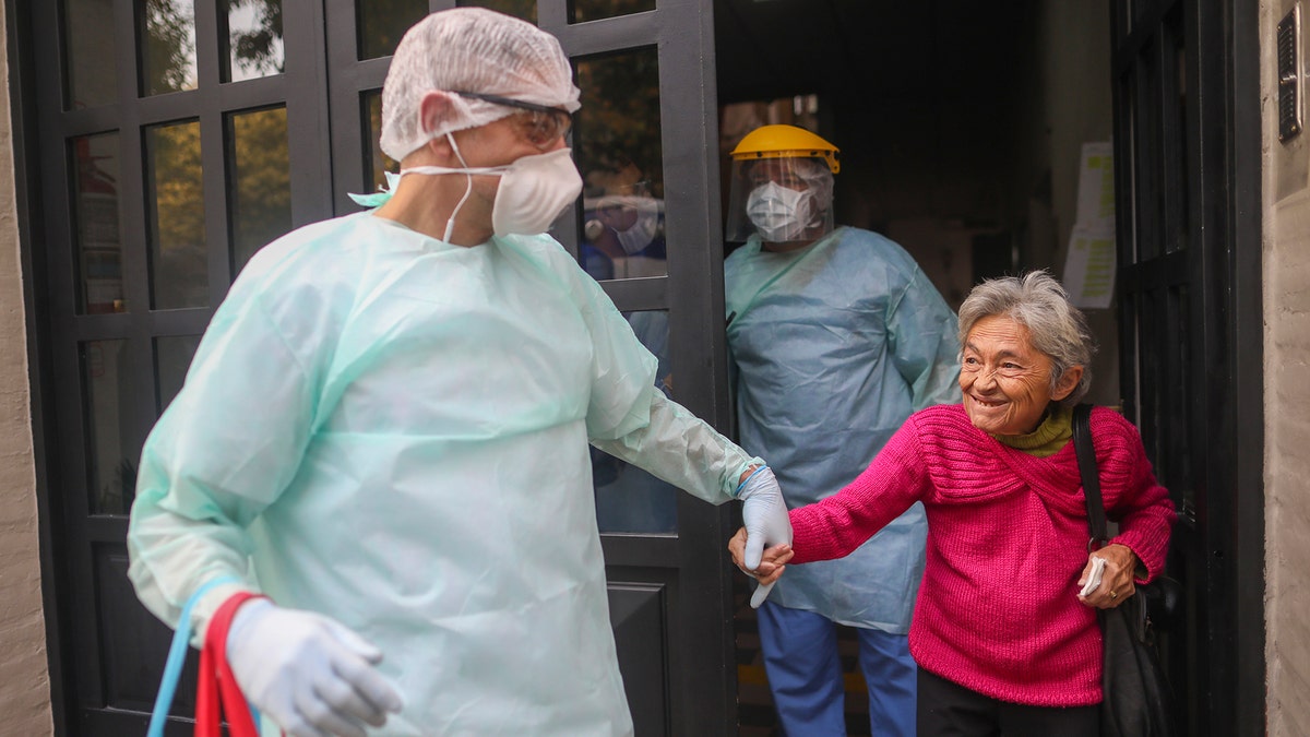 Medical staff evacuate an elderly woman from a nursing home after multiple residents of the facility tested positive for the new coronavirus, in Buenos Aires, Argentina, Wednesday, April 22, 2020. (AP Photo/Natacha Pisarenko)