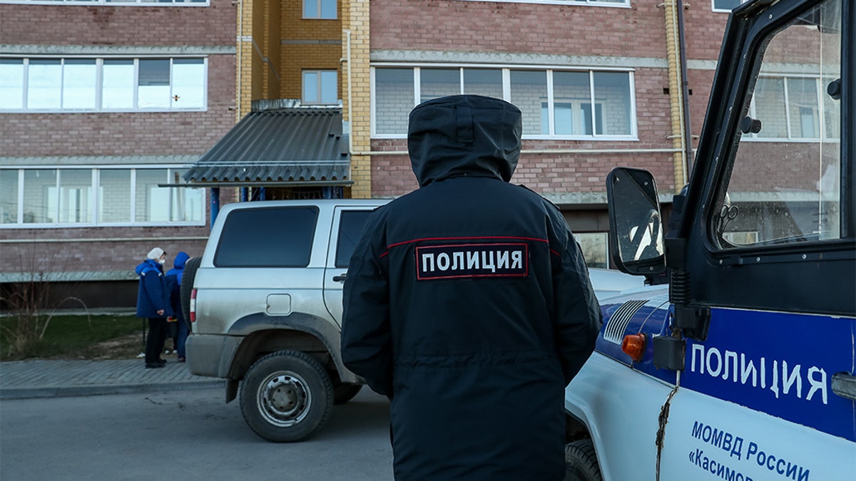 Police at the site of a deadly shooting in an apartment building in the village of Yelatma, Russia.