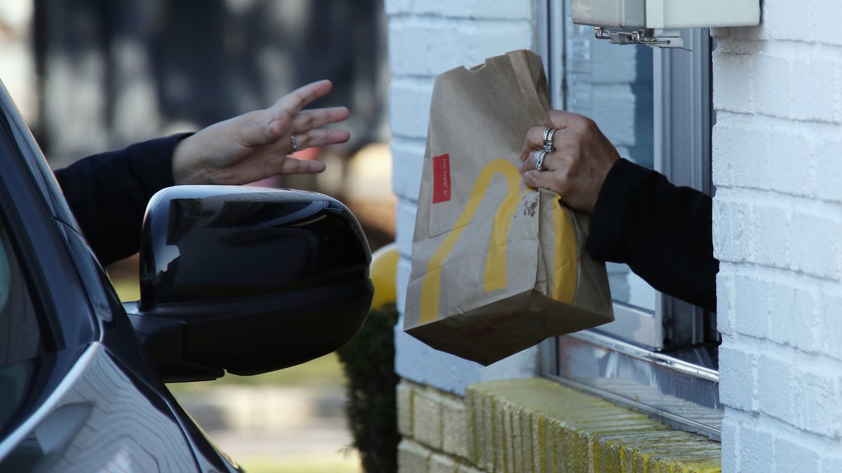 A customer at a McDonald's uses the drive-up window on March 18 in Hicksville, New York. The World Health Organization declared COVID-19 a global pandemic on March 11. (Bruce Bennett/Getty Images)