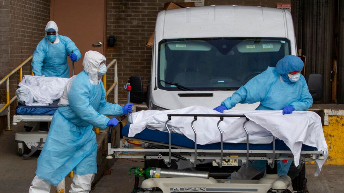 Medical personnel wearing personal protective equipment remove bodies from the Wyckoff Heights Medical Center Thursday, April 2, 2020 in the Brooklyn borough of New York City. (AP Photo/Mary Altaffer)