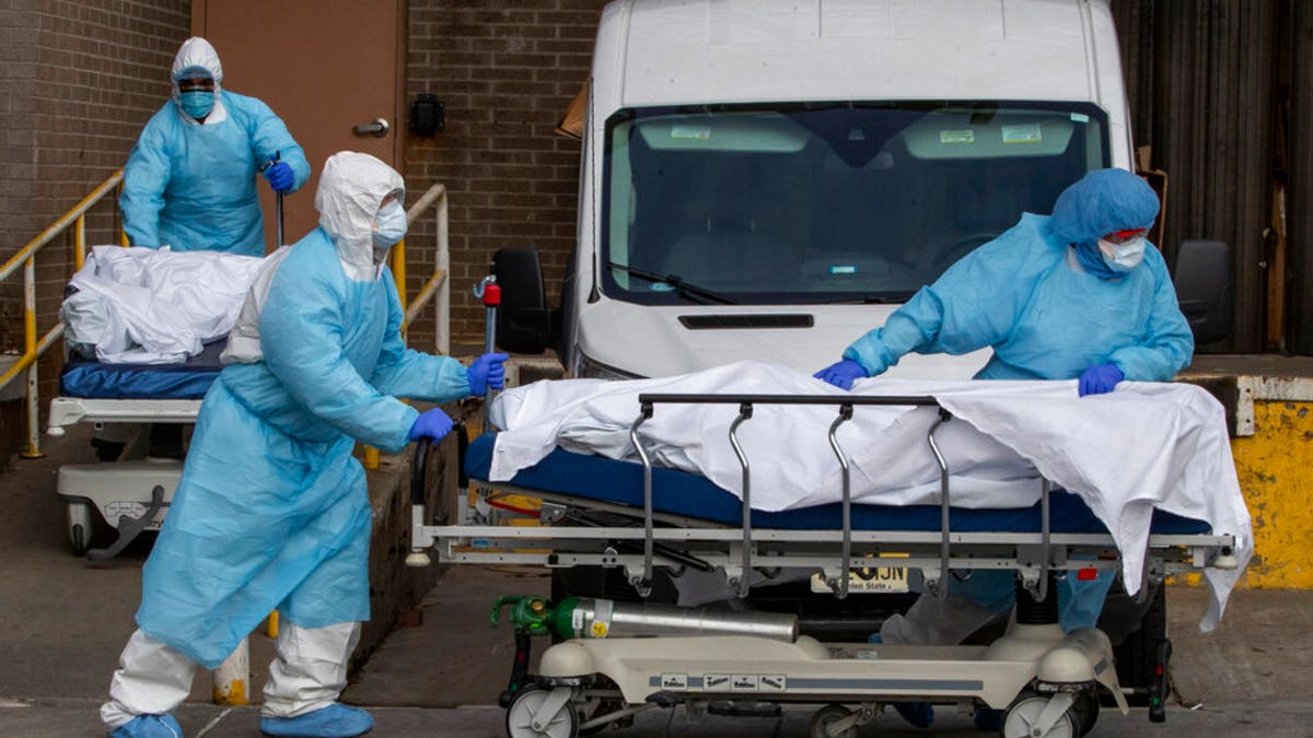 Medical personnel wearing personal protective equipment remove bodies from the Wyckoff Heights Medical Center Thursday, April 2, 2020 in the Brooklyn borough of New York City. (AP Photo/Mary Altaffer)