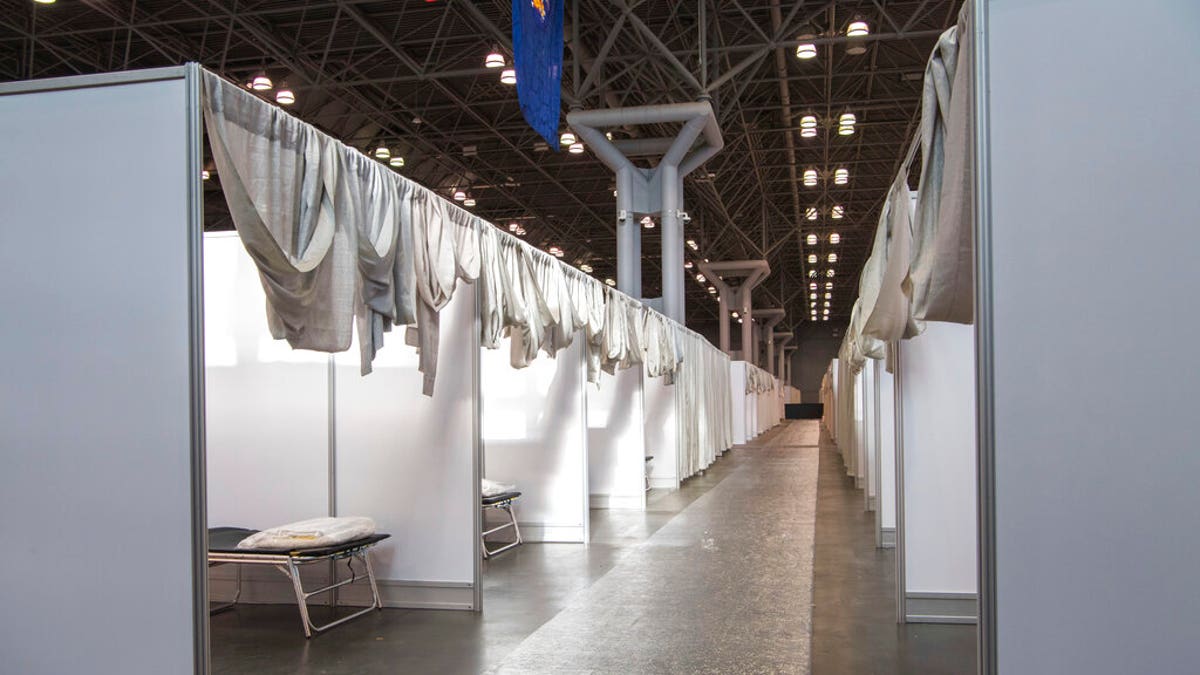 In this Friday, March 27, 2020, photo provided by Office of Governor Andrew M. Cuomo, makeshift hospital rooms stretch out along the floor at the Jacob Javits Convention Center in New York. (Darren McGee/Office of Governor Andrew M. Cuomo via AP)