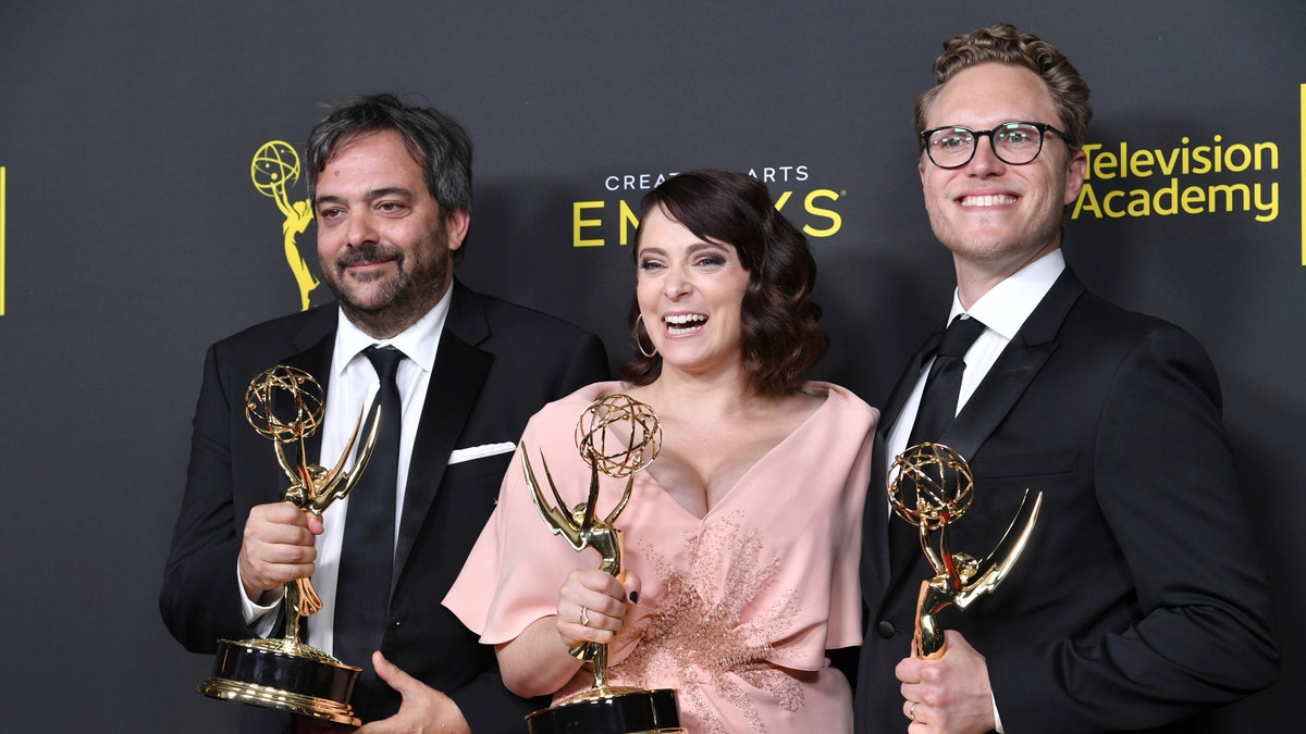 FILE - This Sept. 14, 2019 file photo shows Adam Schlesinger, from left, Rachel Bloom and Jack Dolgen in the press room with the awards for outstanding original music and lyrics for 'Crazy Ex Girlfriend' at the Creative Arts Emmy Awards in Los Angeles. 