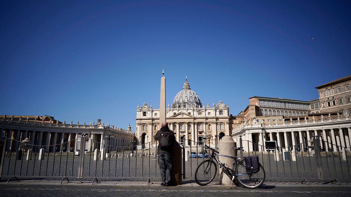 A man stands in front of St. Peter's Square and Basilica during Pope Francis' weekly general audience, streamed by the Vatican television due to restrictions to contain the Covid-19 virus, at the Vatican, Wednesday, April 1, 2020. (Associated Press)