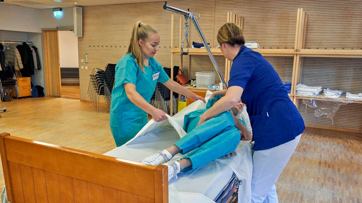 Former Scandinavian Airlines flight attendants learn basic skills on to assist in nursing homes and hospitals due to the coronavirus outbreak, in Stockholm.