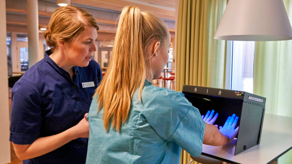 Former Scandinavian Airlines flight attendant, Mathilda Malm tests her hands for bacteria as she learns basic skills on to assist in nursing homes and hospitals due to the coronavirus outbreak, in Stockholm.
