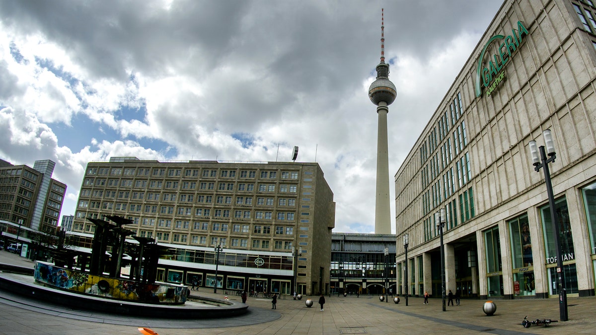 Due to the contact restrictions caused by the new coronavirus outbreak only a few people walk on the famous 'Alexanderplatz' (Alexander Square) in Berlin, Germany, Friday, April 3, 2020. For most people, the new coronavirus causes only mild or moderate symptoms. For some it can cause more severe illness. (AP Photo/Michael Sohn)