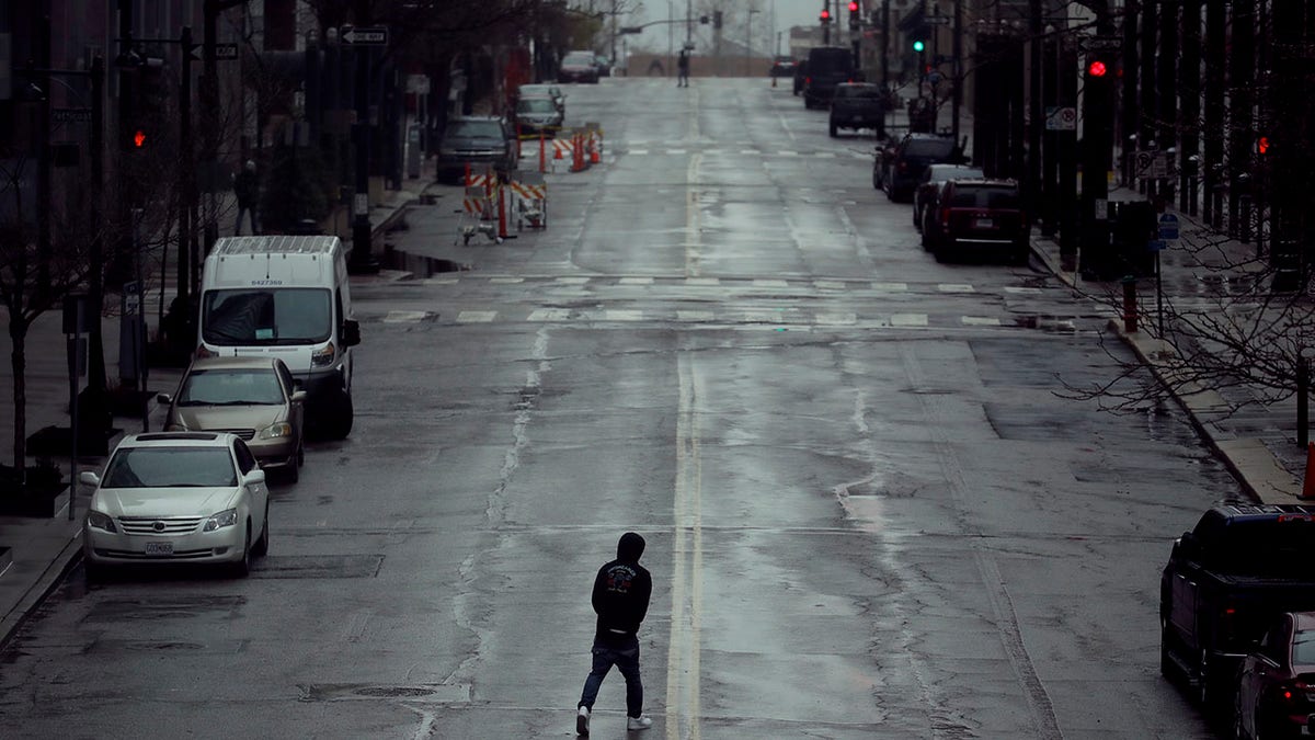 A man crosses an empty street Friday, April 3, 2020 in downtown Kansas City, Mo. The city is under a stay-at-home order, asking everyone to stay inside and away from others as much as possible, in an effort to slow the spread of the new coronavirus. (Associated Press)