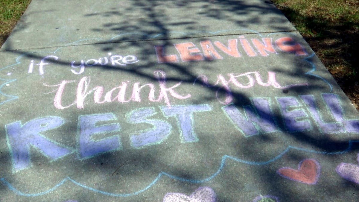 A message written in chalk that reads, "If you're leaving, thank you, rest well," on a sidewalk at Ochsner Medical Center in New Orleans. (AP Photo/Stacey Plaisance)