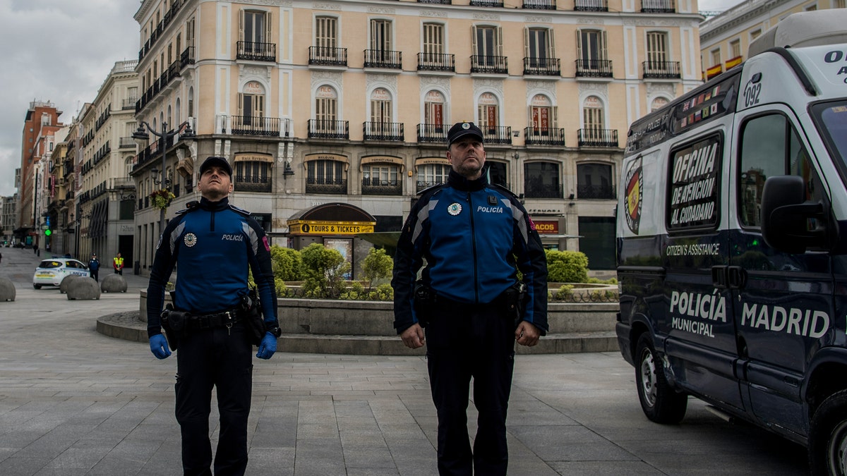 Police officers hold a minute of silence for the victims of COVID-19 as the lockdown to combat the spread of coronavirus continues in downtown Madrid, Spain, Tuesday, April 7, 2020. The new coronavirus causes mild or moderate symptoms for most people, but for some, especially older adults and people with existing health problems, it can cause more severe illness or death. (AP Photo/Manu Fernandez)