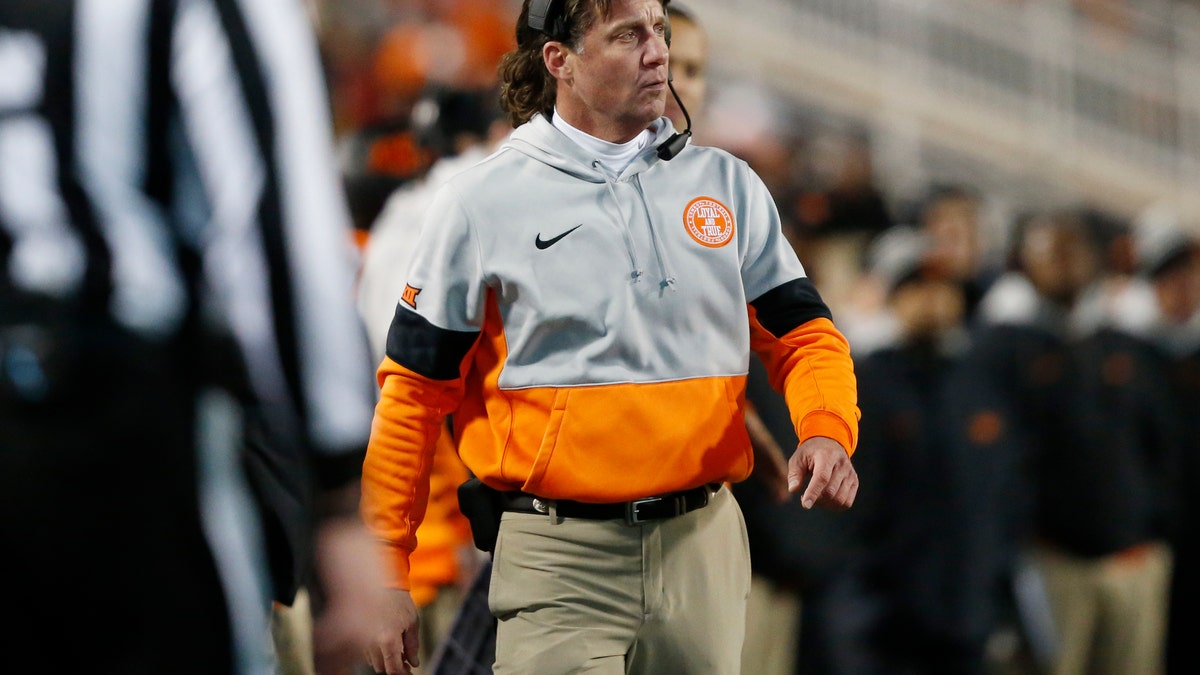 Oklahoma State head coach Mike Gundy walks on the sidelines during an NCAA college football game against Oklahoma in Stillwater, Okla. last November. Gundy said Tuesday, April 7, 2020 he hopes to have his team return to its facilities on May 1, a proposed timetable that would defy federal social-distancing guidelines and was quickly disputed by the university and its athletic director. (AP Photo/Sue Ogrocki)