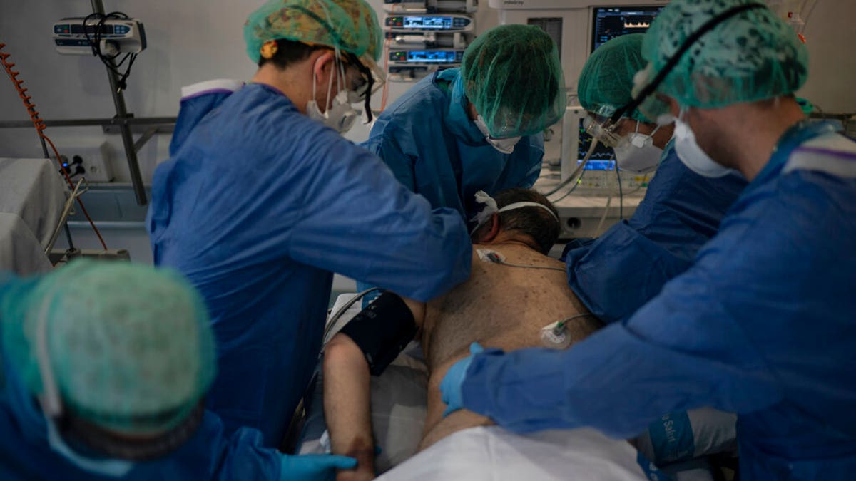 Healthcare workers assist a COVID-19 patient at a library that was turned into an intensive care unit (ICU) at Germans Trias i Pujol hospital in Badalona, Barcelona province, Spain. 