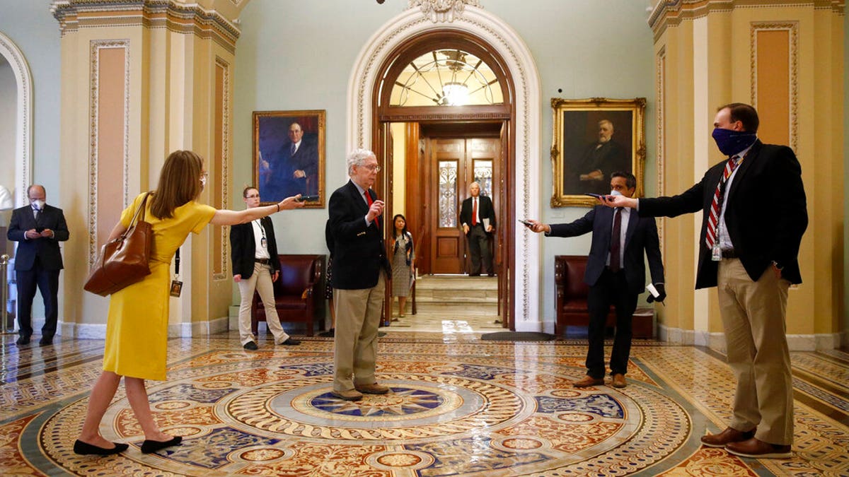 Senate Majority Leader Mitch McConnell of Ky., center, speaks with reporters outside the Senate chamber on Capitol Hill in Washington, Thursday, April 9, 2020. Senate Democrats on Thursday stalled President Donald Trump's request for $250 billion to supplement a "paycheck protection" program for businesses crippled by the coronavirus outbreak, demanding protections for minority-owned businesses and money for health care providers and state and local governments. (AP Photo/Patrick Semansky)