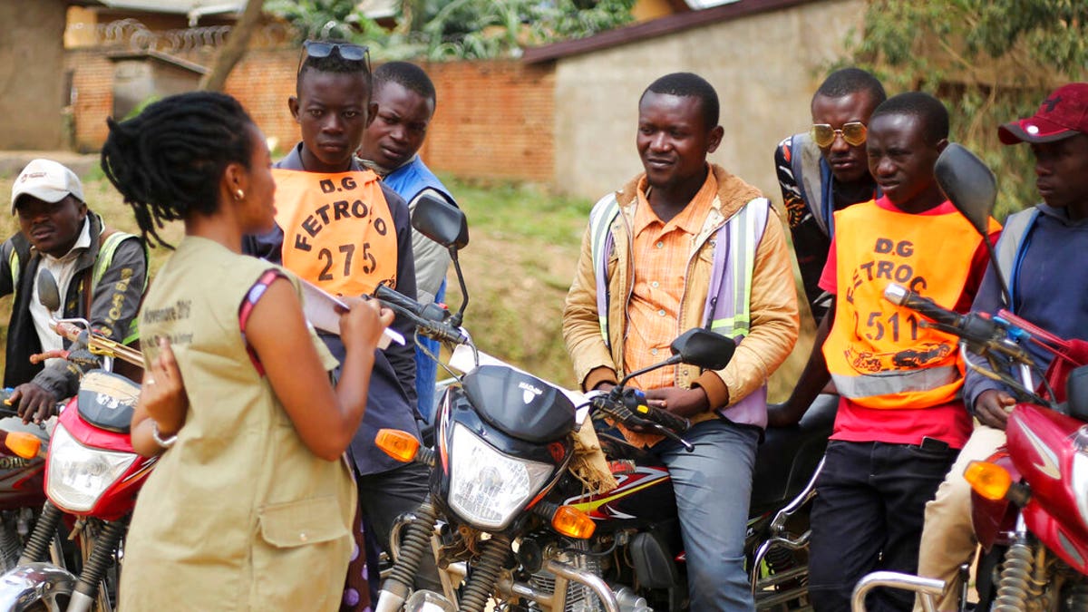 Martine Milonde, left, a Congolese community mobilizer who works with the aid group World Vision in Beni, eastern Congo, which became the epicenter of the Ebola outbreak, engages the public about coronavirus prevention.