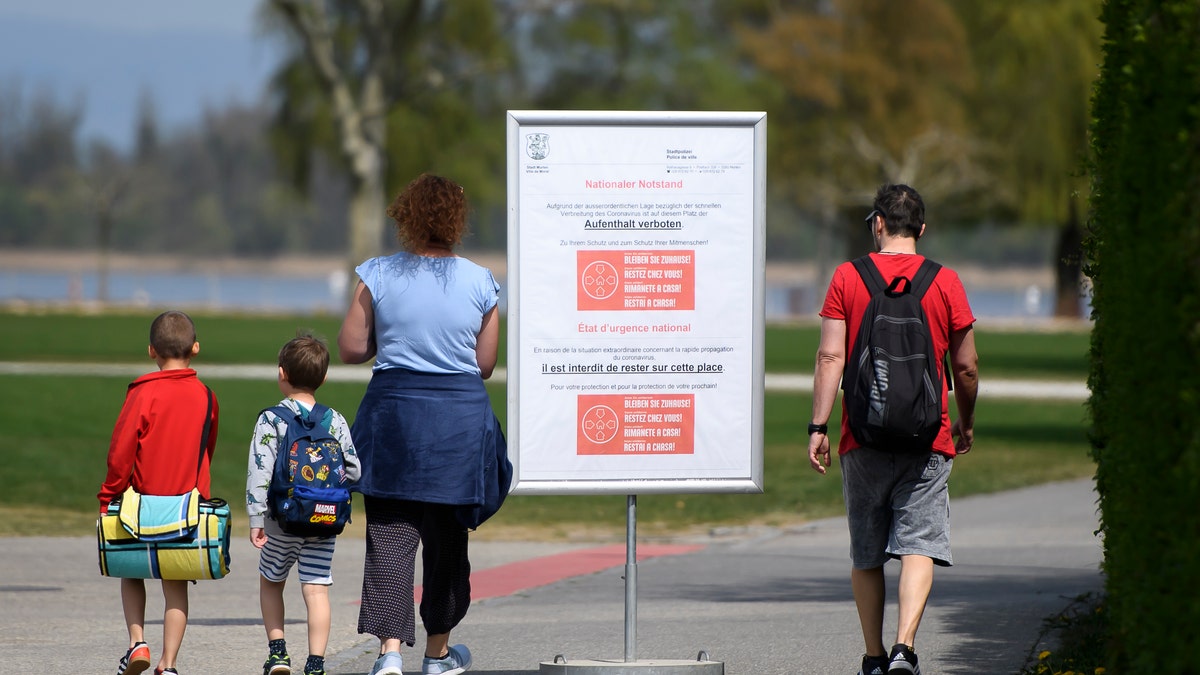 A billboard photographed Monday on the shore of Switzerland's Lake Murten says "it is forbidden to stay on this square."