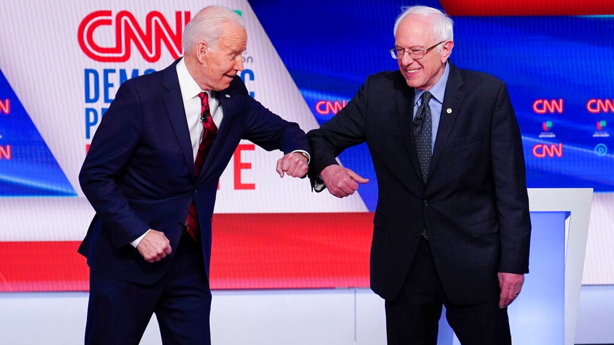 FILE - In this March 15, 2020, file photo, former Vice President Joe Biden, left, and Sen. Bernie Sanders, I-Vt., right, greet one another before they participate in a Democratic presidential primary debate at CNN Studios in Washington. Sanders said Tuesday that it would be 