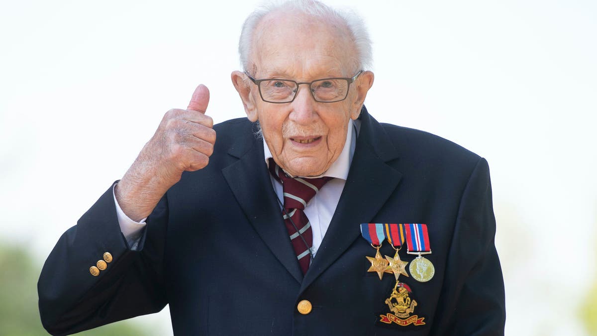 99-year-old war veteran Captain Tom Moore, poses for a photo at his home in Marston Moretaine, England, after he achieved his goal of 100 laps of his garden, raising millions of pounds for the NHS with donations to his fundraising challenge from around the world, Thursday April 16, 2020. (Joe Giddens/PA via AP)