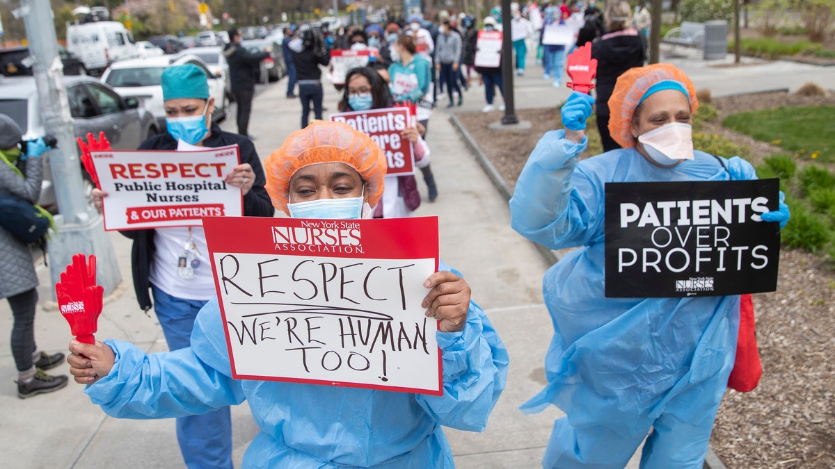 Nurses hold a demonstration outside Jacobi Medical Center to protest a new policy by the hospital requiring a doctor's note for paid sick leave, Friday, April 17, 2020, in the Bronx borough of New York. (AP Photo/Mary Altaffer)