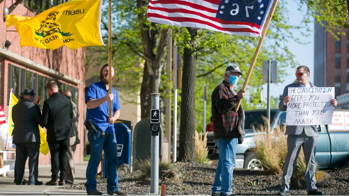 Kenton Gartrell, Patrick Ray and Garth McKinney, from left, attend a rally to protest the Yakima City Council's decision to formally censure Councilman Jason White, Tuesday, April 21, 2020, outside City Hall in Yakima, Wash. 