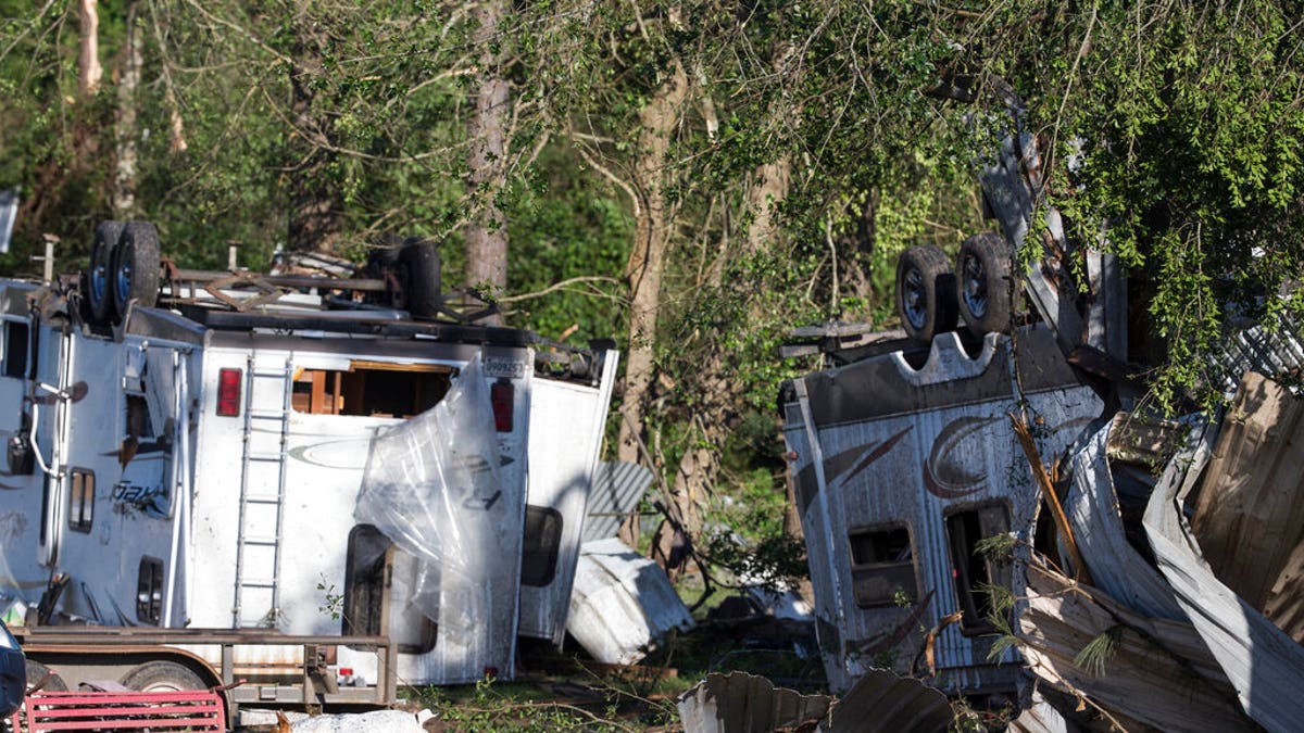 A dog walks past overturned trailers, Thursday, April 23, 2020, in Onalaska, Texas, after a tornado destroyed came through the area night before. 