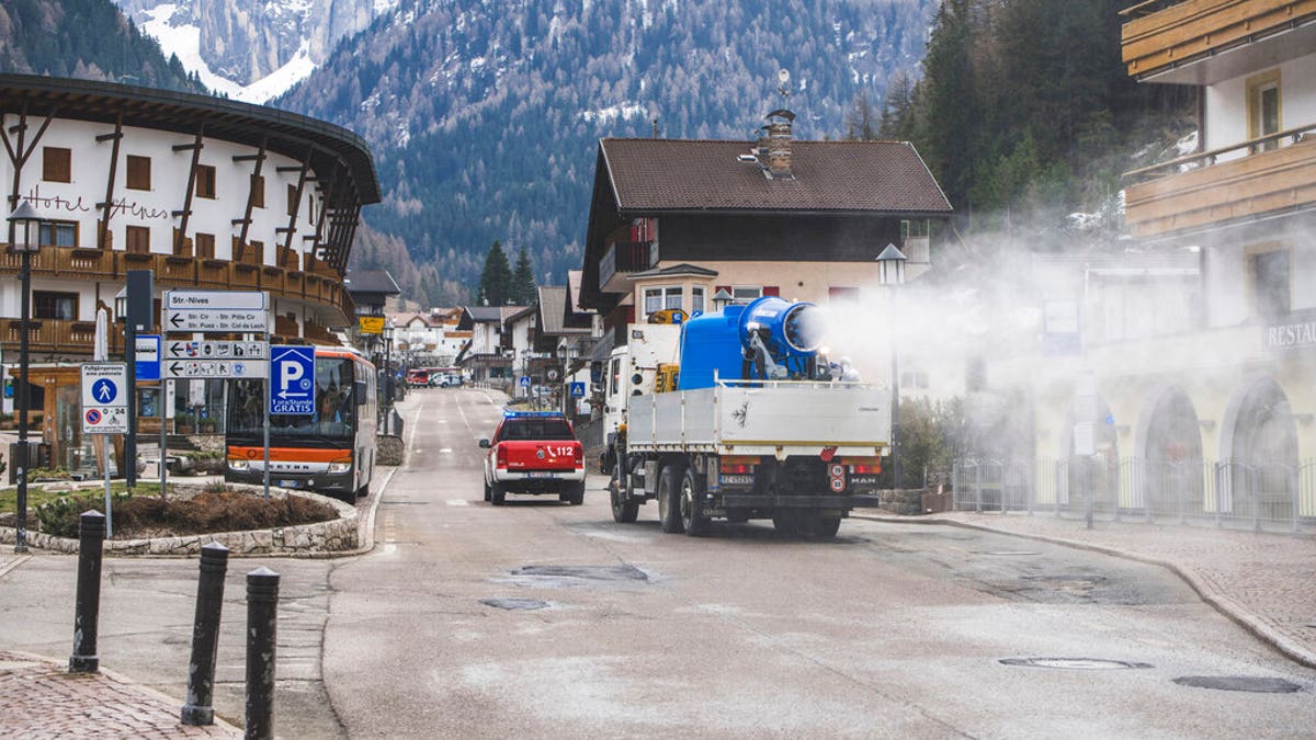 A truck equipped with a snow cannon fed with diluted hydrogen peroxide sanitizes the streets in Selva di Val Gardena, Northern Italy, Thursday, April 23, 2020.