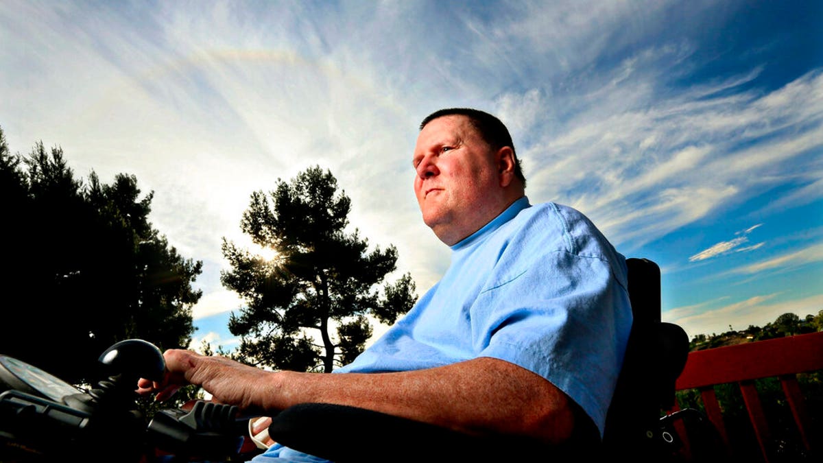 In 2013, Dan Walters, a former police officer who was paralyzed in 2003 after being shot in the neck, sits in his wheelchair on his back porch at home in San Diego. 
