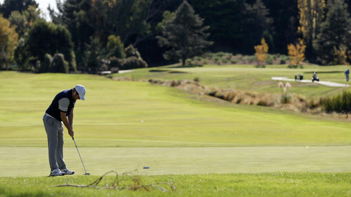 A man prepares to putt on a green at a golf course as level four COVID-19 restrictions are eased in Christchurch, New Zealand, Tuesday, April 28, 2020. New Zealand eased its strict lockdown restrictions to level three at midnight to open up certain sections of the economy but social distancing rules will still apply. 