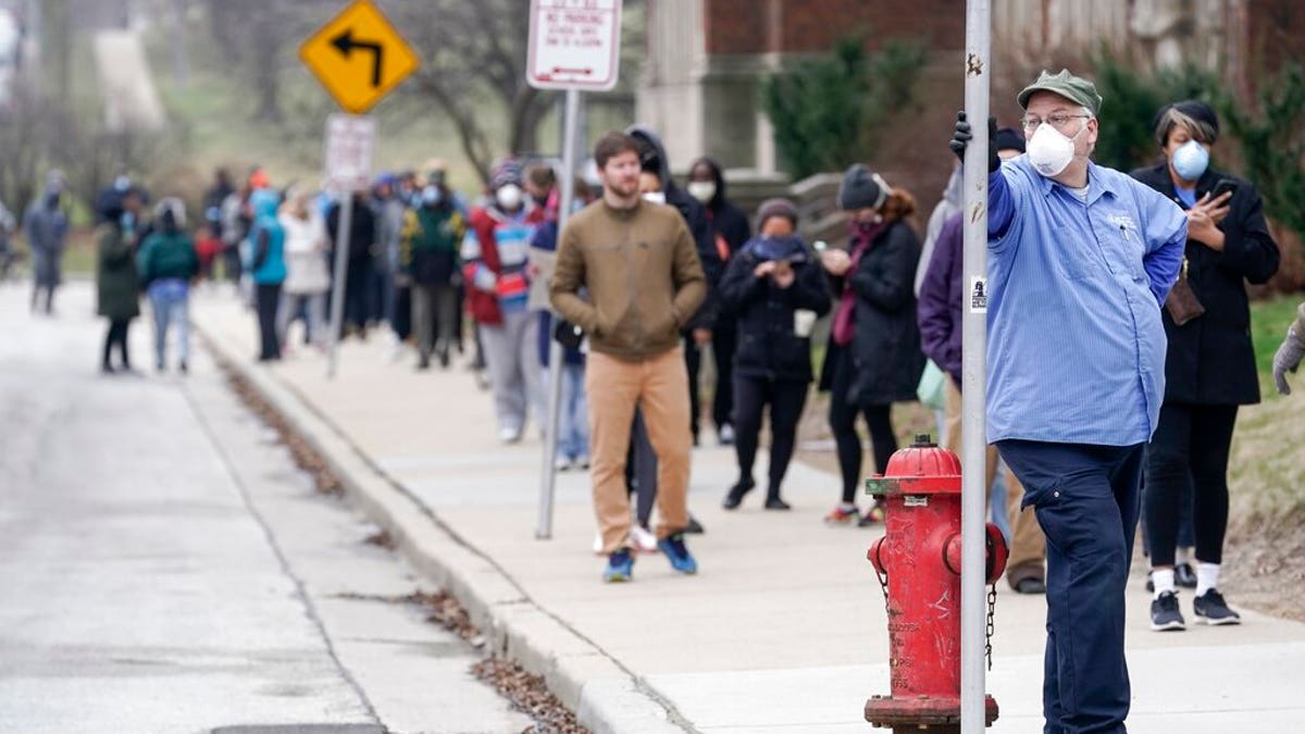 FILE - In this April 7, 2020 file photo, voters observe social distancing guidelines as they wait in line to cast ballots in the presidential primary election in Milwaukee. More than 50 people who voted in person or worked the polls during Wisconsin's election earlier this month have tested positive for COVID-19 so far. But there are no plans to move or otherwise alter a special congressional election coming in less than two weeks. (AP Photo/Morry Gash File)