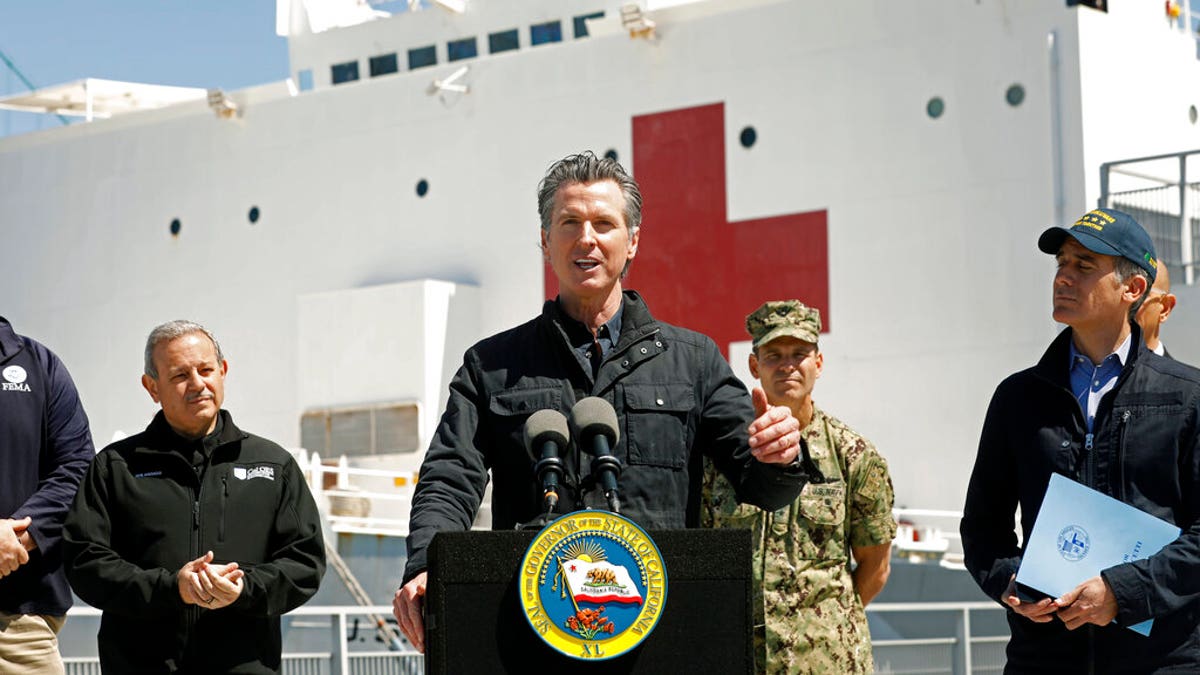FILE: California Governor Gavin Newsom, center, speaks next to Los Angeles Mayor Eric Garcetti, right, in front of the hospital ship USNS Mercy that arrived into the Port of Los Angeles.