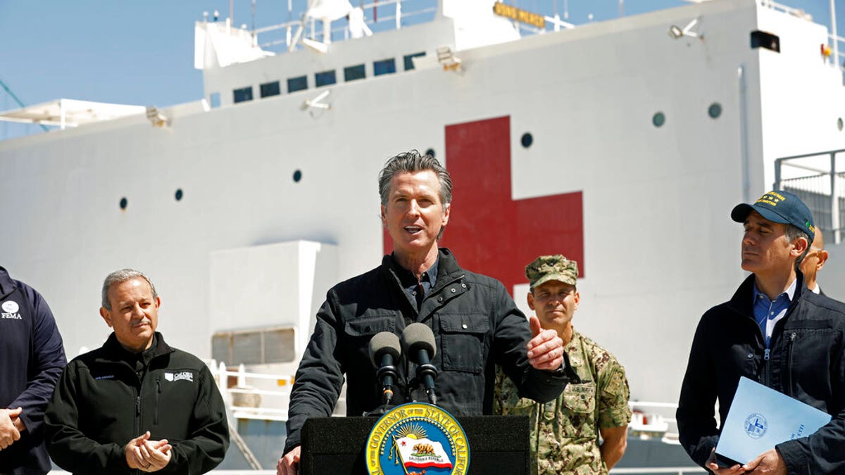 FILE: California Governor Gavin Newsom, center, speaks next to Los Angeles Mayor Eric Garcetti, right, in front of the hospital ship USNS Mercy that arrived into the Port of Los Angeles.