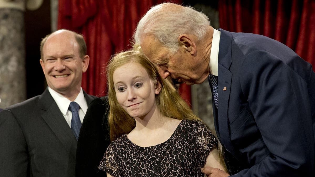 Then-Vice President Joe Biden leans in to say something to Maggie Coons, next to her father Sen. Chris Coons, D-Del., after Biden administered the Senate oath to Coons during a ceremonial re-enactment swearing-in ceremony, Jan. 6, 2015, in the Old Senate Chamber of Capitol Hill in Washington. (AP Photo/Jacquelyn Martin)