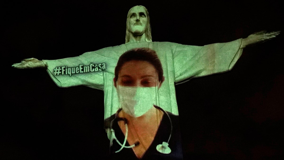 Rio's Christ the Redeemer statue is lit up with an image of a doctor during an Easter service, amidst the new coronavirus pandemic, in Rio de Janeiro, Brazil, Sunday, April 12, 2020. (AP Photo/Silvia Izquierdo)