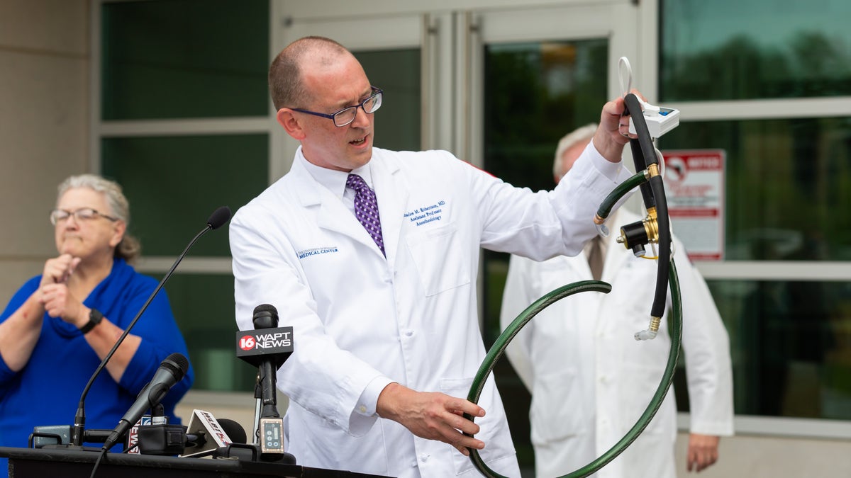 Dr. Charles Robertson, assistant professor of anesthesiology, holds up a ventilator built from garden hose and other readily available parts. The ventilators are meant for use only if UMMC exhausts other ventilator options. (University of Mississippi Medical Center)