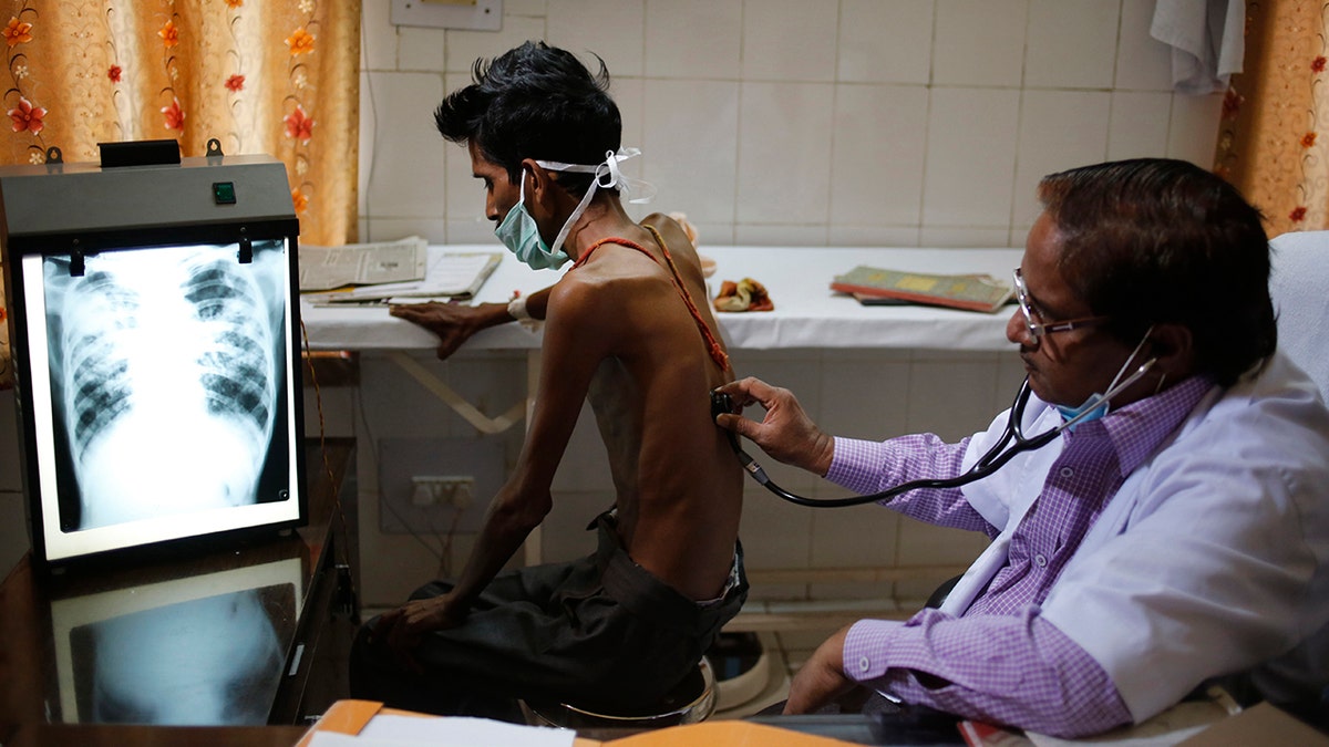 FILE - In this March 24, 2014, file photo, a doctor examines a tuberculosis patient in a government TB hospital in Allahabad, India. (AP Photo/Rajesh Kumar Singh, File)