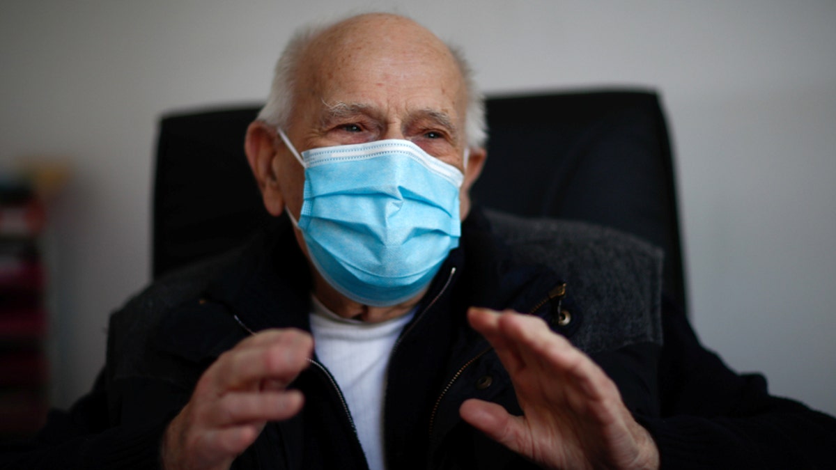 French doctor Christian Chenay, 98 year-old, wearing a protective face mask, sits in his consulting room at the doctor's office in Chevilly-Larue near Paris as the spread of the coronavirus disease (COVID-19) continues in France April 14, 2020. Picture taken April 14, 2020.