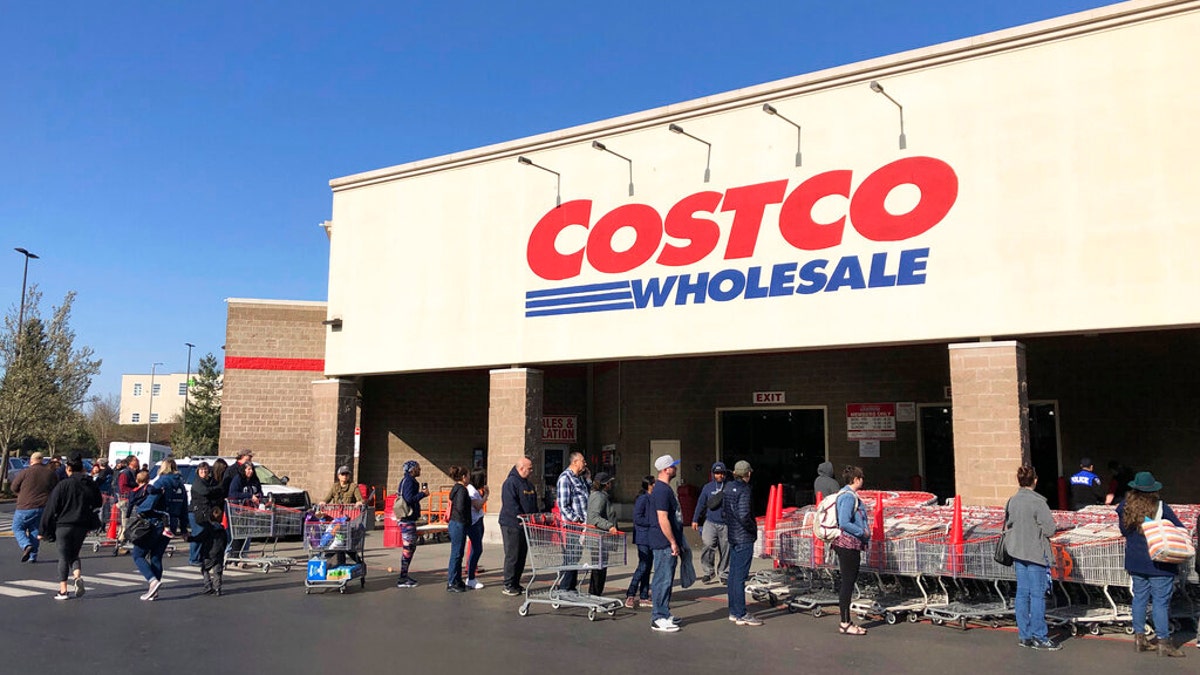 Shoppers are seen lining up to enter a Costco store in Tacoma, Wash., on March 20.