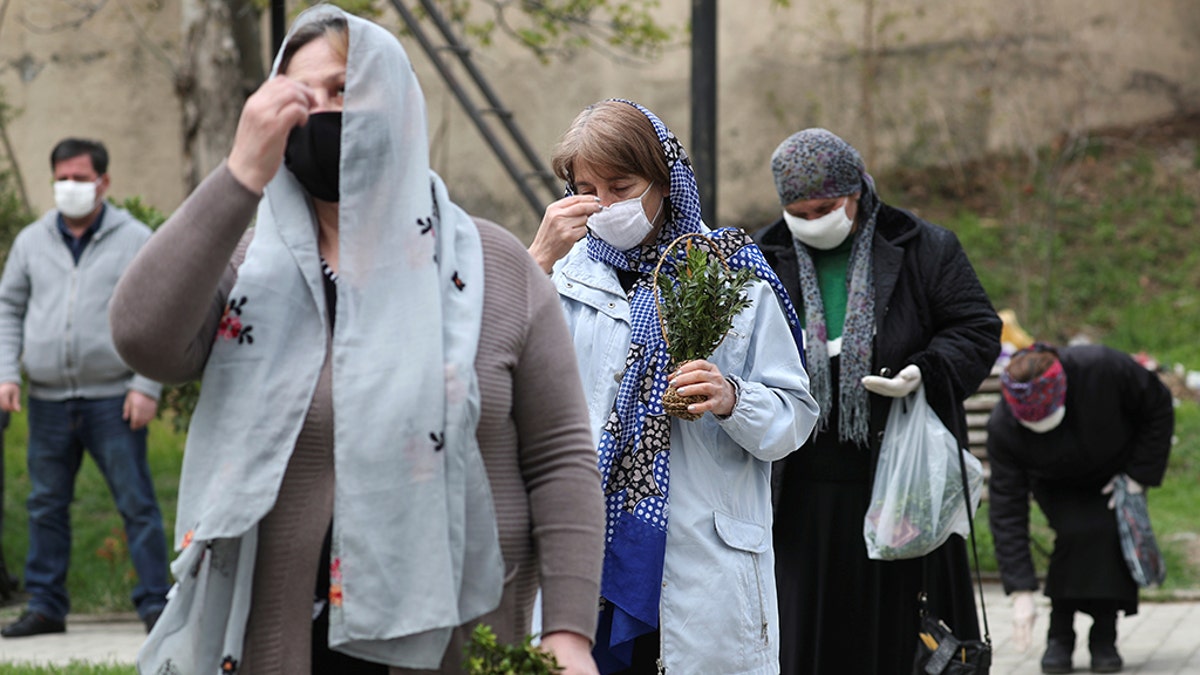 Believers wearing protective masks gather outside a church during a service, which marks the Orthodox feast of Palm Sunday, amid the coronavirus disease (COVID-19) outbreak in Marneuli, Georgia April 12, 2020. 