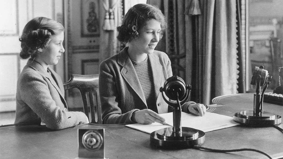 Then-Princess Elizabeth making her first broadcast, accompanied by her younger sister Princess Margaret Rose, on October 12, 1940, in London.