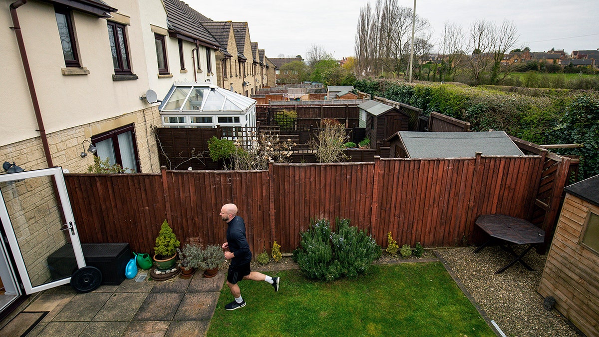 James Campbell runs a charity marathon to raise funds for the NHS, in his garden, while the country is in lockdown to control the spread of coronavirus, in Cheltenham, England, April 1, 2020. The former international athlete is spending his birthday running - in his seven-meter-long back garden - and will take over 7,000 shuttles back and forth to finish the 26.2-mile marathon. (Jacob King/PA via AP)