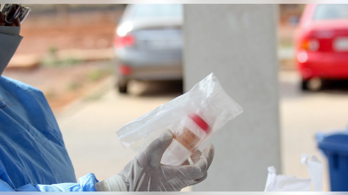 Staff in Ghana unbox a COVID-19 test sample that was transported via drone from a rural village.