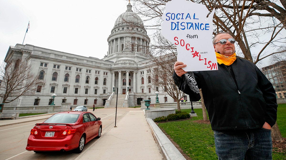Protesters against the coronavirus shutdown rally in front of State Capitol in Madison, Wisconsin, on April 24, 2020. - The coronavirus pandemic soared past 50,000 in the US. (Photo by KAMIL KRZACZYNSKI / AFP) (Photo by KAMIL KRZACZYNSKI/AFP via Getty Images)