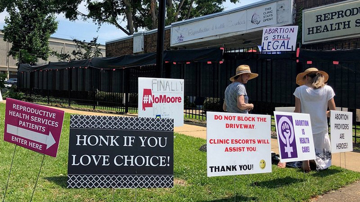 In this May 17, 2019, file photo, abortion opponents kneel in prayer outside Reproductive Health Services, an abortion clinic in Montgomery, Ala. (AP Photo/Blake Paterson, File)