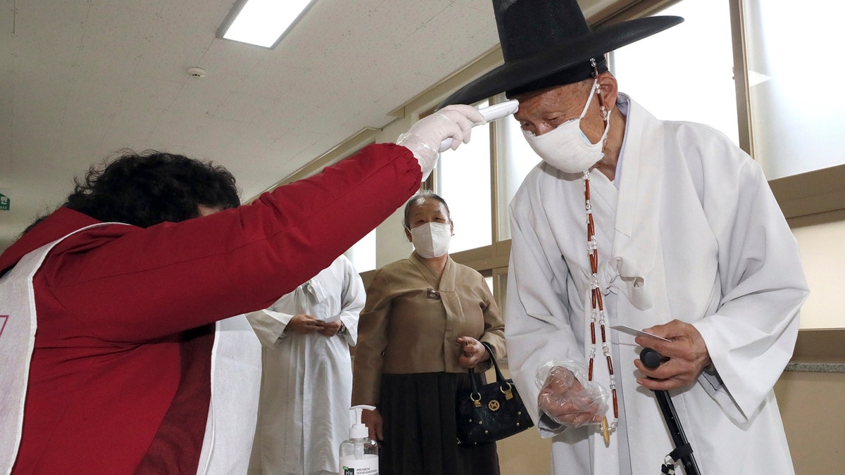South Korean voters wore masks and moved slowly between lines of tape at polling stations on Wednesday to elect lawmakers in the shadows of the spreading coronavirus.