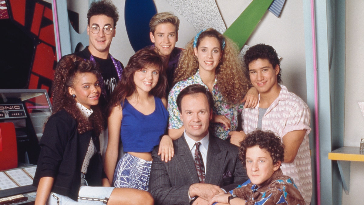 The original cast of "Saved by the Bell," left to right: Lark Voorhies as Lisa, Ed Alonzo as Max, Tiffani Thiessen as Kelly, Mark-Paul Gosselaar as Zack, Dennis Haskins as Mr. Belding, Elizabeth Berkley as Jessie, Dustin Diamond as Screech and Mario Lopez as A.C. (Photo by NBCU Photo Bank/NBCUniversal via Getty Images via Getty Images)