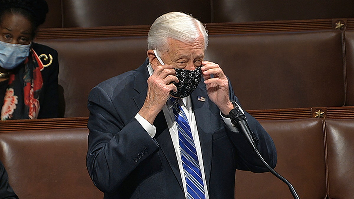 Rep. Steny Hoyer, D-Md., takes his face covering off as he speaks on the floor of the House of Representatives at the U.S. Capitol in Washington, Thursday, April 23, 2020. 