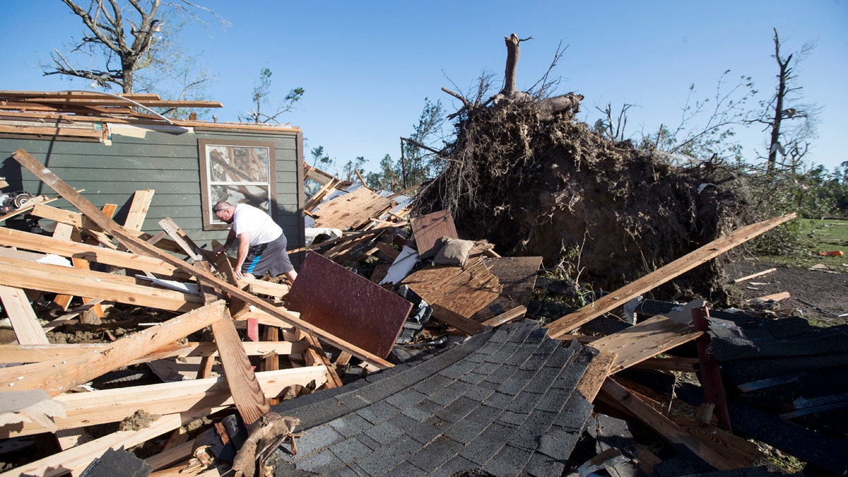 David Maynard sifts through the rubble searching for his wallet, Thursday, April 23, 2020, in Onalaska, Texas, after a tornado destroyed his home the night before.
