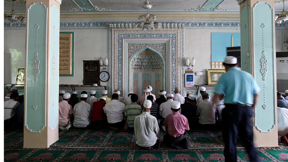 Ethnic Uighurs pray inside a mosque in Urumqi